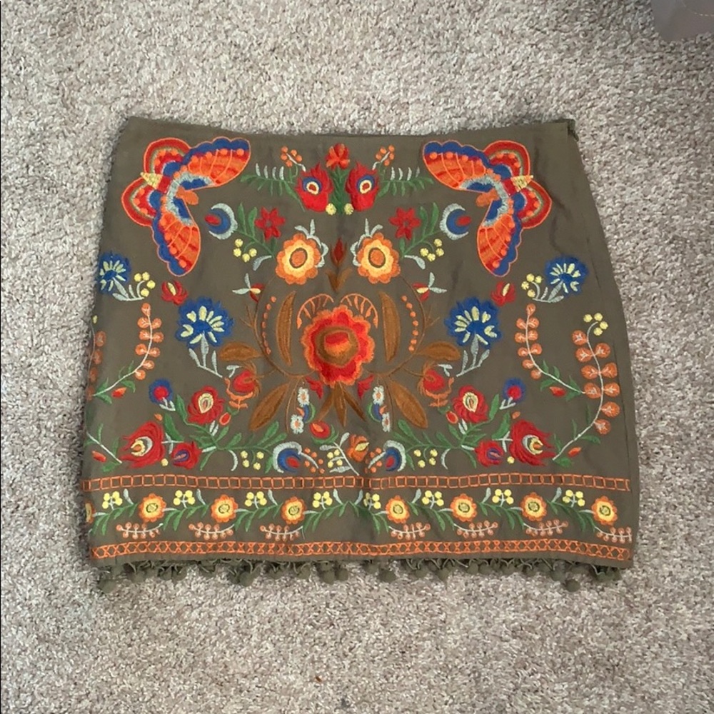 Embroidered skirt with pom pom detailing.